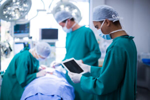 Surgeon using digital tablet in operation theater of hospital